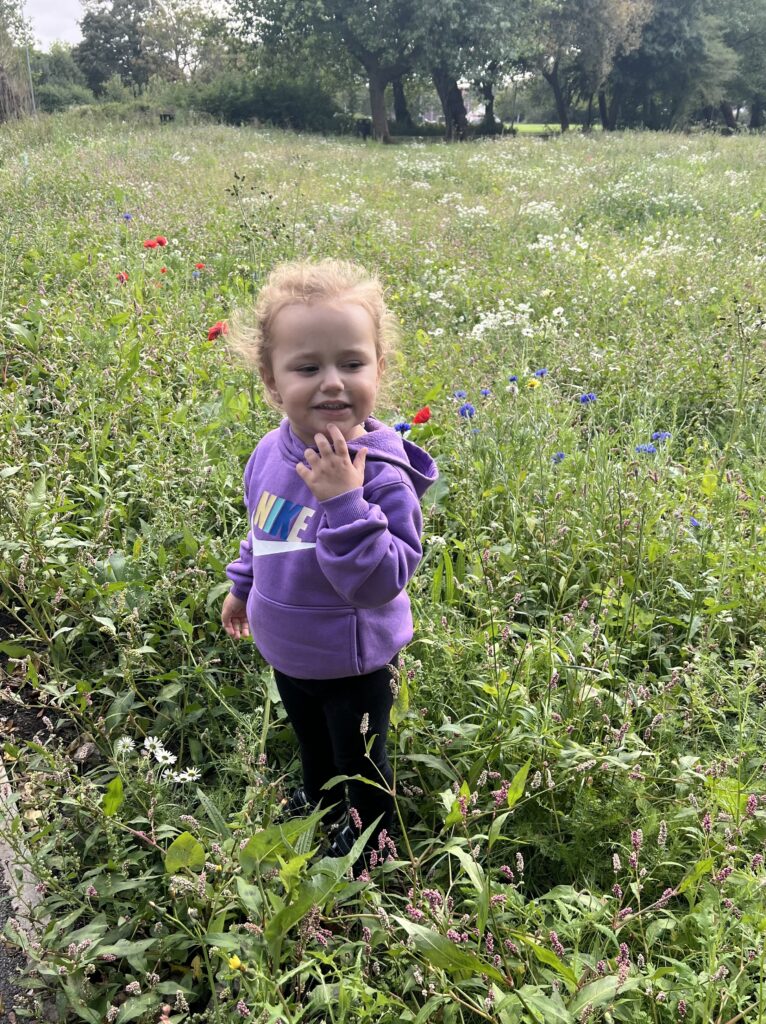 Esmai smelling the flowers