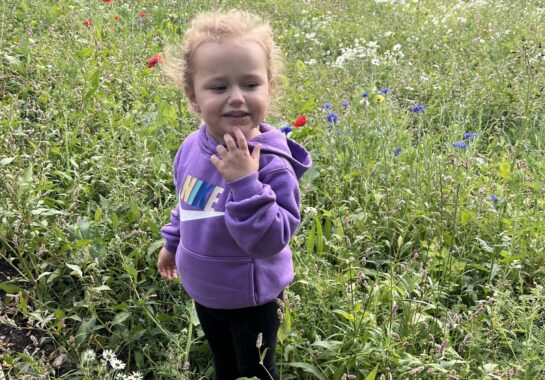 Esmai smelling the flowers