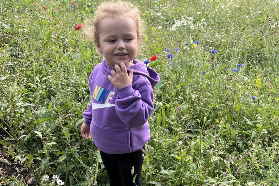 Esmai smelling the flowers