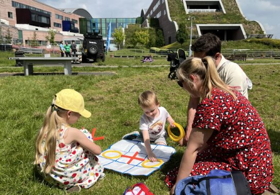 Family playing in Springfield Park next to Alder Hey