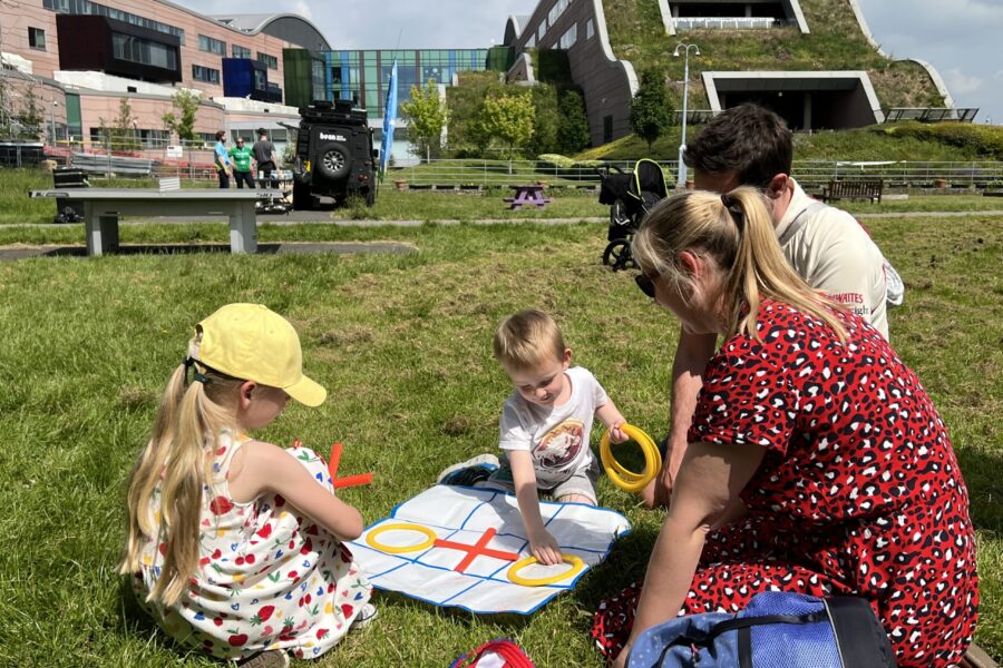 Family playing in Springfield Park next to Alder Hey