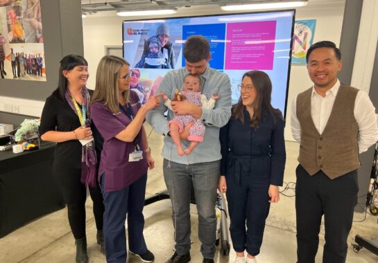 Parents post with their baby and Alder Hey Innovation team members