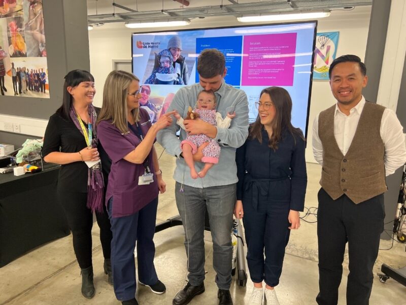 Parents post with their baby and Alder Hey Innovation team members